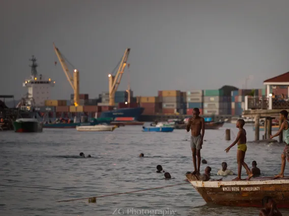 Boys standing on a boat in a harbor