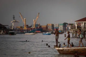 Boys standing on a boat in a harbor